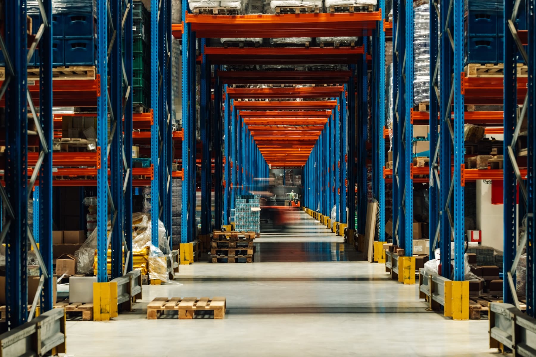 Forklift operator moving pallets in a warehouse